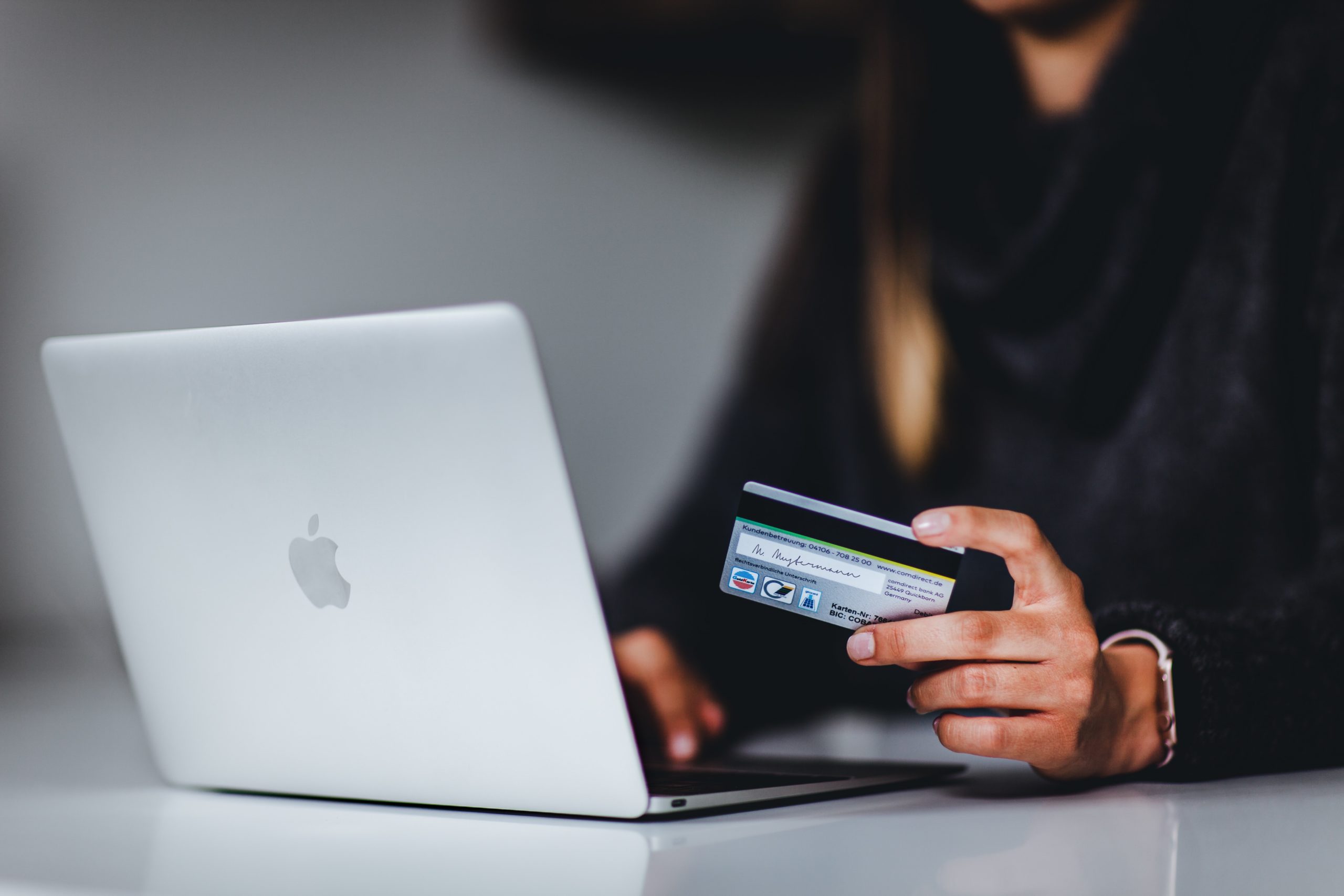 woman purchasing on a laptop with her credit card e-commerce