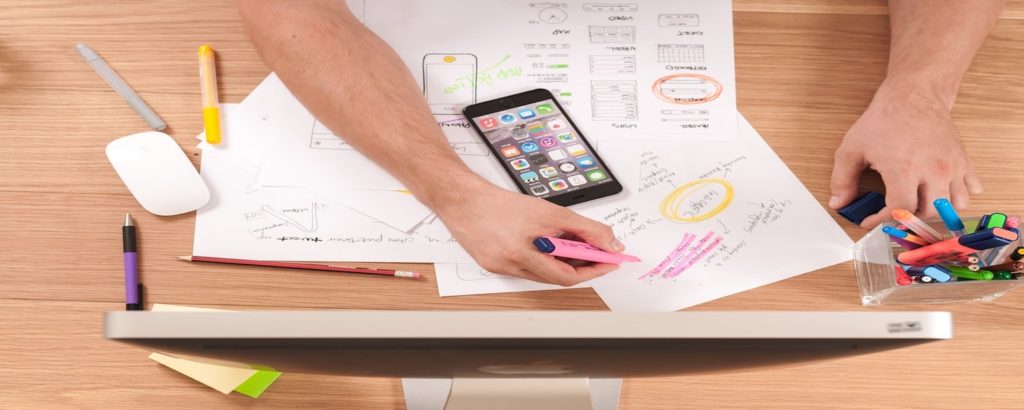 A desk with papers of a person doing a competitor analysis